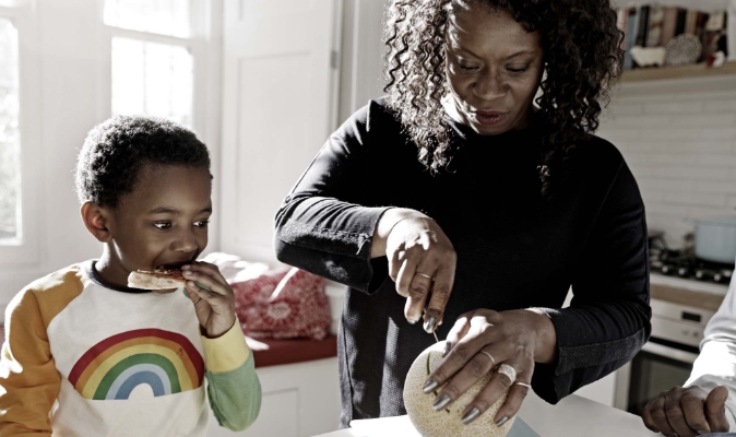Woman helping child prepare food